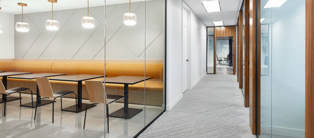 Modern office meeting and collaboration area with custom banquette seating and global furniture tables by The Office Shop.