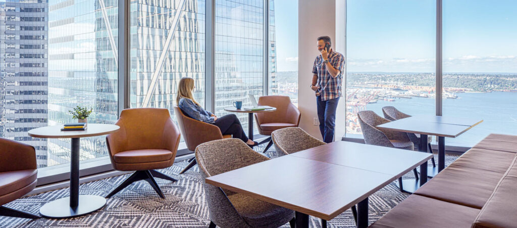 Professional office lounge and collaborative workspace featuring global furniture group, a canadian office furniture manufacturers, chairs and tables with a city and water view. 
