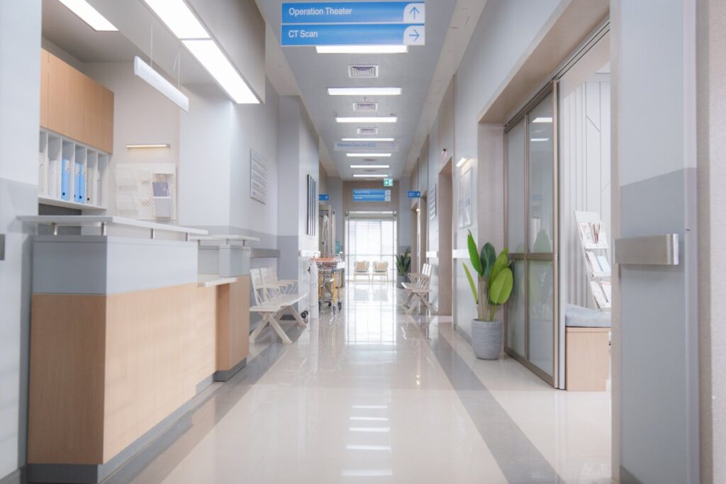 Bright hospital hallway with reception desk, waiting chairs, and cleanable finishes, illustrating how healthcare furniture in Canada balances comfort and compliance.