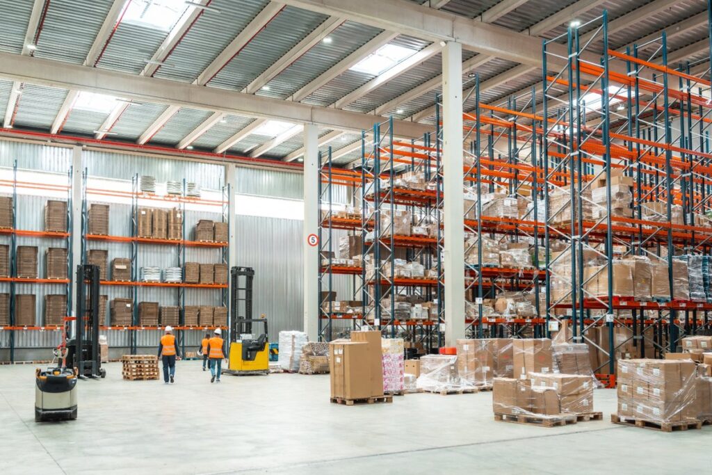 Large warehouse with shelves, pallets, and storage systems, representing secure and organized healthcare furniture in Canada for protecting supplies and privacy.