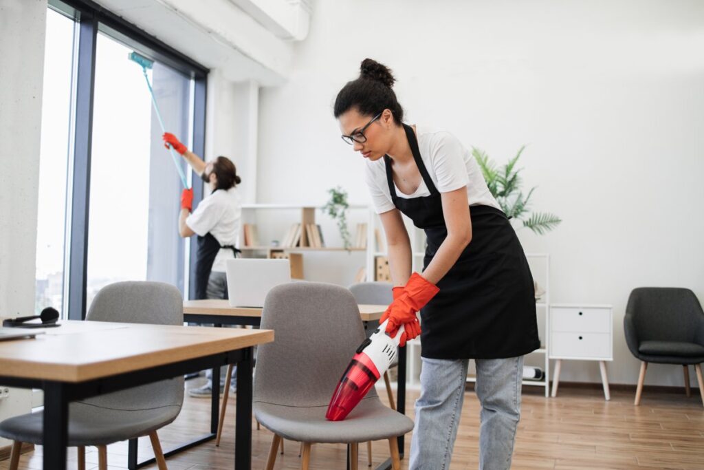 Workers sanitizing clinic furniture and surfaces, highlighting healthcare furniture in Canada designed for infection control and easy maintenance.