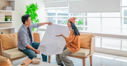 Professional office furniture consultation with two colleagues reviewing a workspace planning sheet