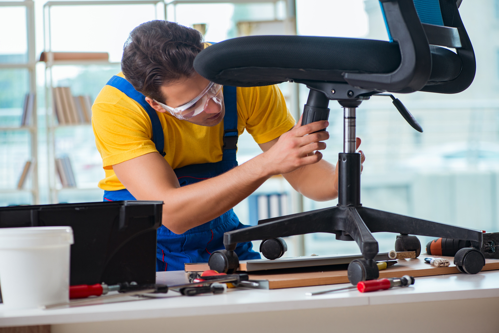 Team assembling desks and workstations during an office furniture installation project in a modern workplace.