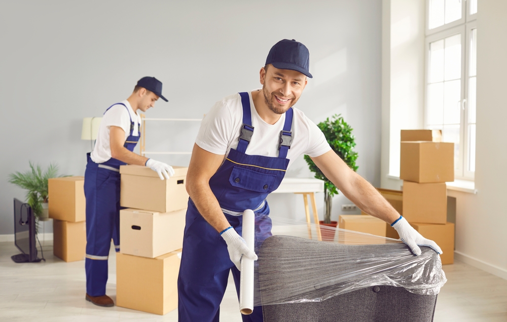 Workers disassembling and removing office desks, chairs, and storage units as part of an office furniture removal.