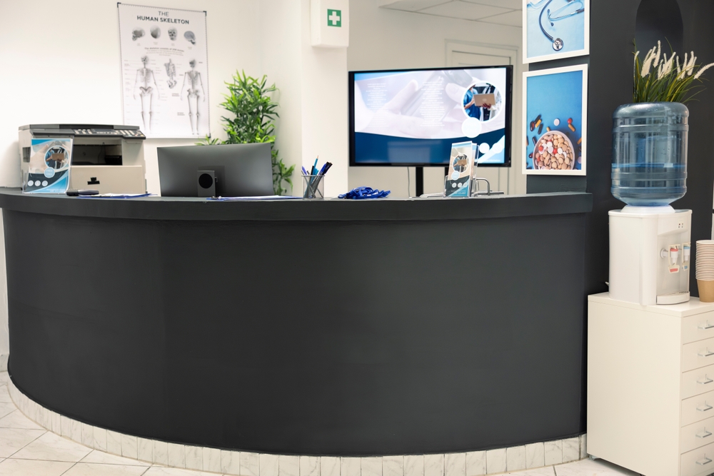 Contemporary workplace entrance showcasing an elegant office reception desk with seating and organized workspace features.
