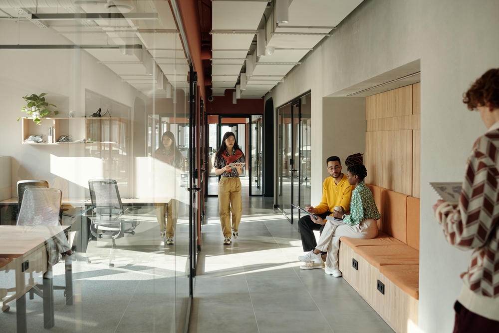 Office benching systems with white desks and low screens in a bright open office in Ontario